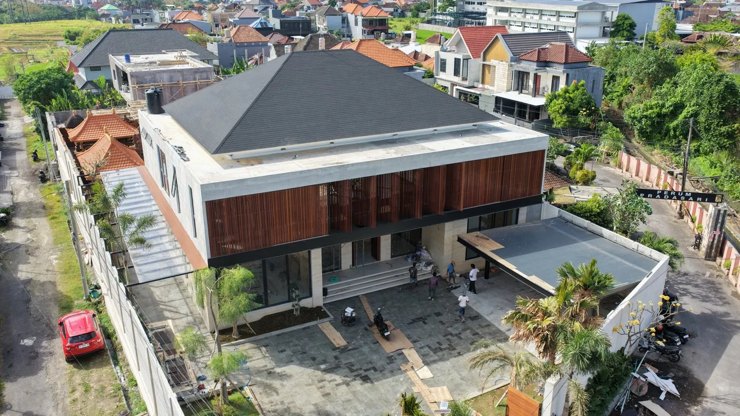 Aerial view of a two-storey timber-panelled house in a residential neighbourhood.