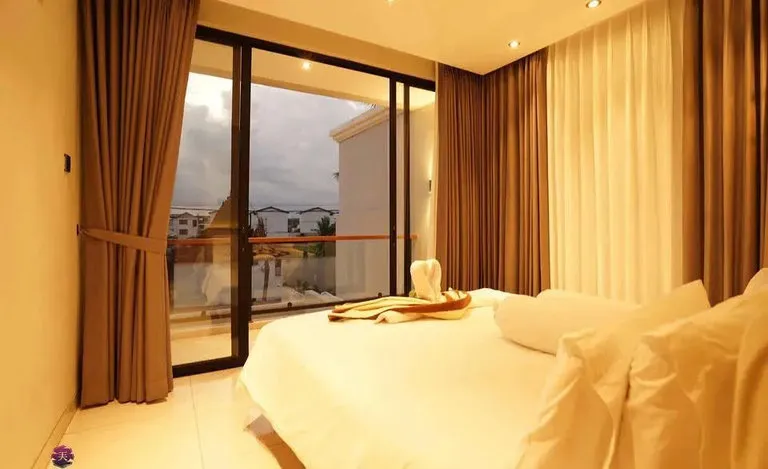A bedroom with brown curtains and sliding glass doors.
