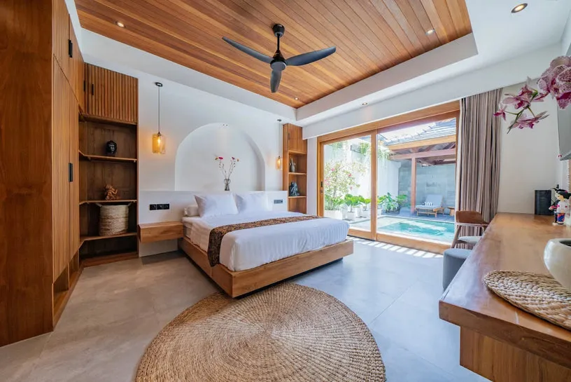 A bedroom with a timber ceiling and a round woven rug.