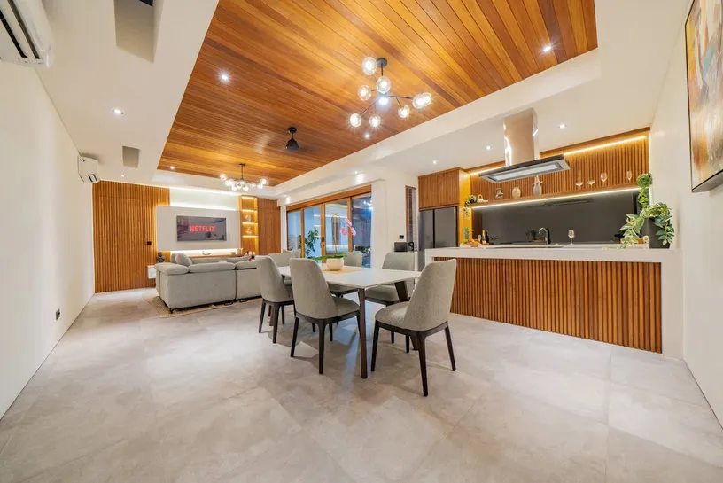 An open dining area and kitchen with a timber ceiling.