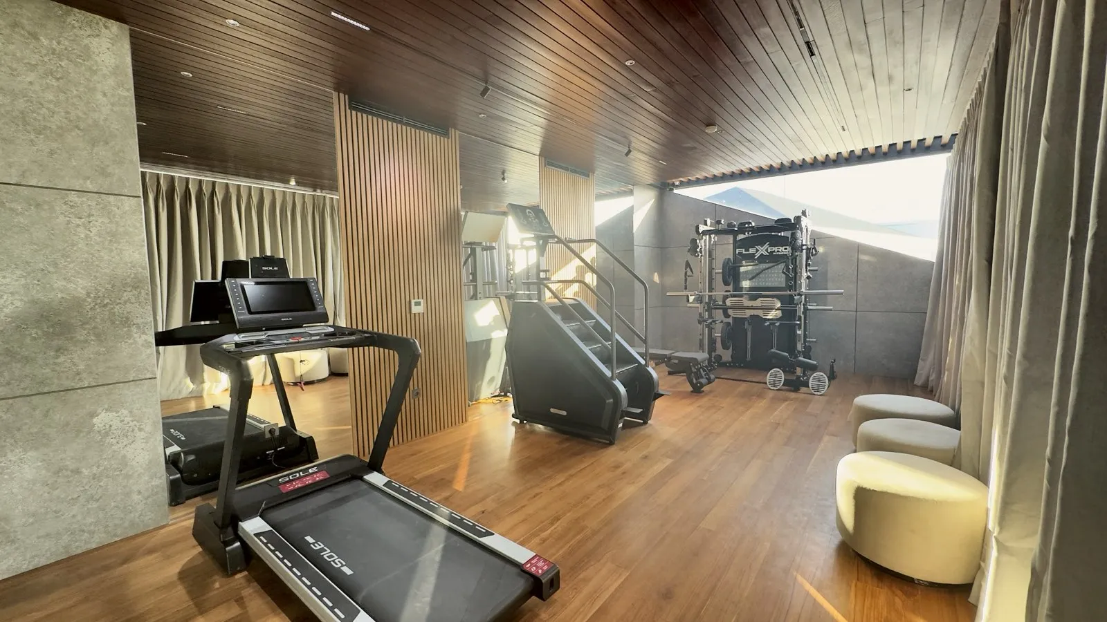 A gym with timber flooring, timber screens and curtains.