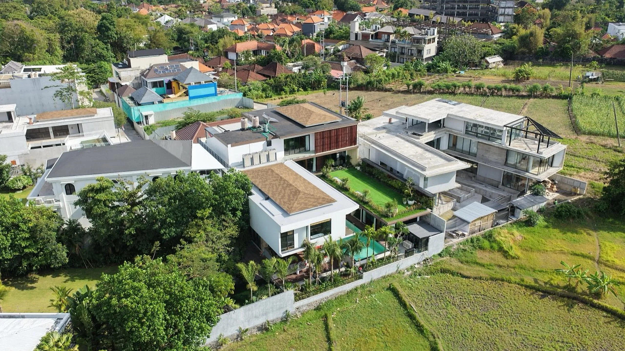 Aerial view of Villa Natsu surrounded by trees and rice fields.
