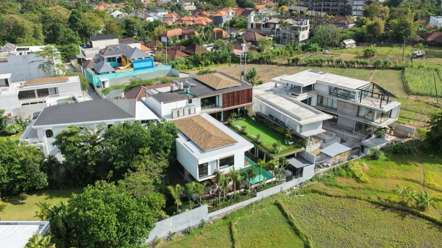 Aerial view of Villa Natsu surrounded by trees and rice fields.
